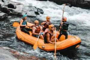 A group of people in an orange raft on a river.
