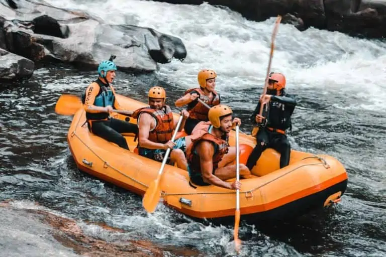 A group of people in an orange raft on a river.